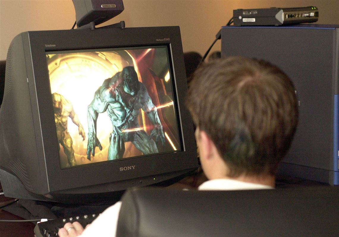 A staff member at id Software, Inc. battles one of the many assorted monsters facing players of  the 2004 release of the  Doom video game at a workstation at the company's headquarters in Mesquite, Texas.