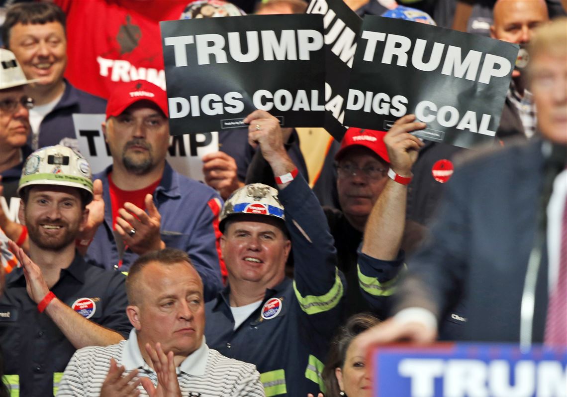 In this May 5, 2016 photo, Coal miners wave signs as Donald Trump speaks during a rally in Charleston, W.Va. Trump's election could signal the end of many of President Barack Obama's signature environmental initiatives.