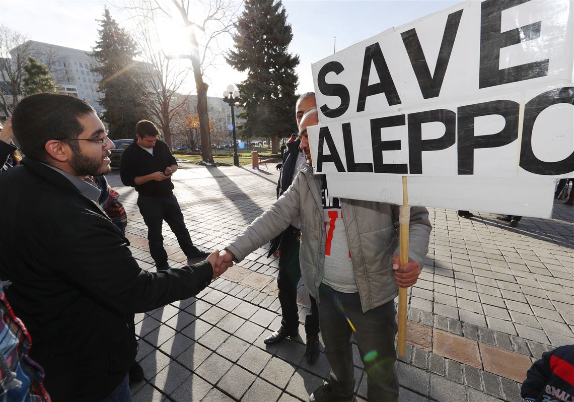 Denver restaurateur Obeid Kaifo, left, greets a supporter after a protest outside the State Capitol Tuesday, Dec. 13, 2016, in downtown Denver. Protesters joined forces with four state lawmakers calling for the United States to take action to protect the people of Aleppo, Syria. Kaifo said that he has lost four family members during the fighting in Aleppo. (AP Photo/David Zalubowski)