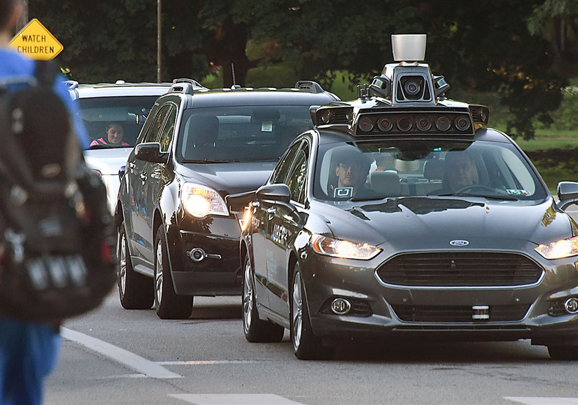 An Uber self-driving Ford Fusion sits at a redlight on Beechwood Boulevard in Squirrel Hill.