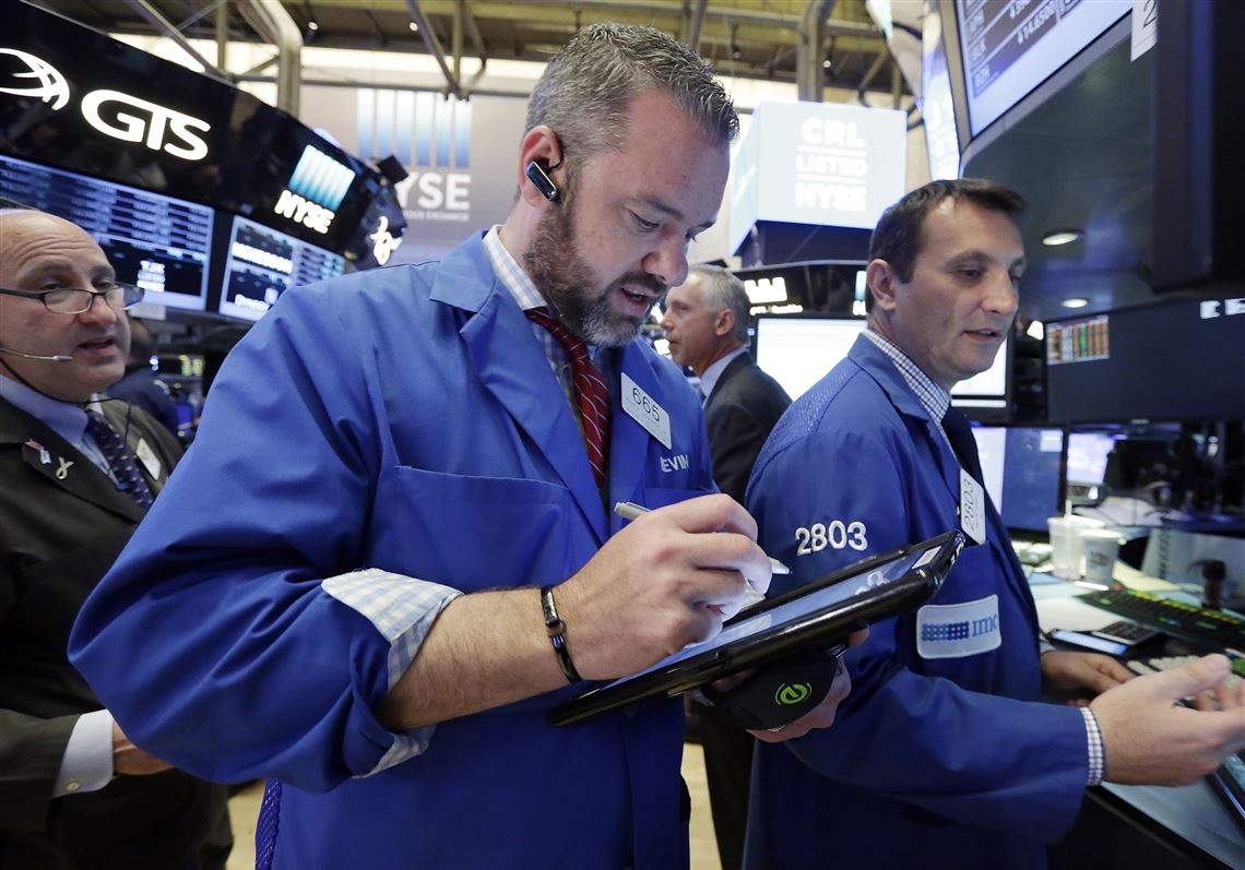 FILE - In a Tuesday, May 23, 2017 file photo, trader Kevin Lodewick, center, works on the floor of the New York Stock Exchange. U.S. stock indexes edged mostly lower in early trading Monday, June 5, 2017, led by a slump in real estate companies. Technology stocks and banks bucked the broader market slide.  (AP Photo/Richard Drew, File)