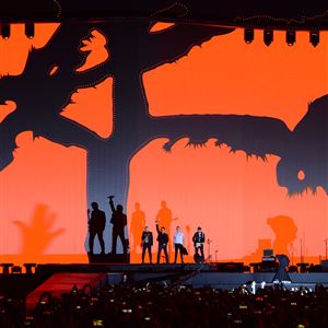 A flash cast shadows on stage as U2 band members, from left Adam Clayton, Bono, Larry Mullen, Jr. and The Edge arrive on stage to play 