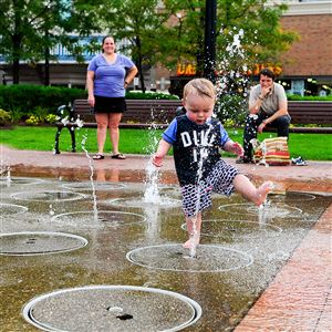Children play in the water fountain at SouthSide Works.