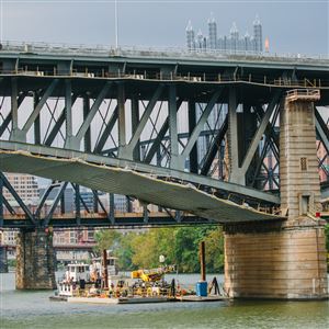 A barge used by repair crews to fix the Liberty Bridge is can be seen below the bridge on the Monongahela river in September.