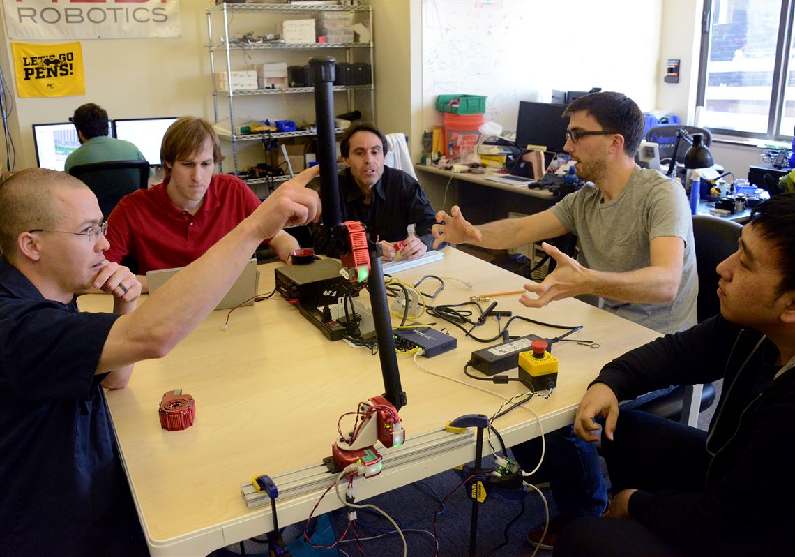 From left, Dave Rollinson, Matthew Tesch, Howie Choset, Curtis Layton and Hoon Ki Kim discuss a development of a robot arm at HEBI Robotics in May in Bloomfield.