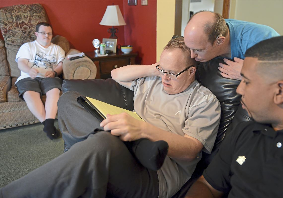 Matthew Mittelmeier, center, 49, prepares the weekly meal plan with input from housemates Jason Tessling, left, 34, and David Petrucco, second from right, 48, along with  Jovan Harris, a senior direct suppport specialist with Emmaus Community of Pittsburgh, Wednesday, August 30, 2017, at a group home in Mt. Lebanon.   (Rebecca Droke/Post-Gazette)