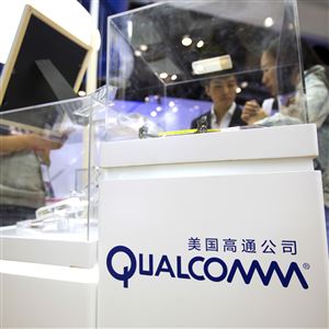 In this April 27, 2017, file photo, visitors look at a display booth for Qualcomm at the Global Mobile Internet Conference (GMIC) in Beijing.