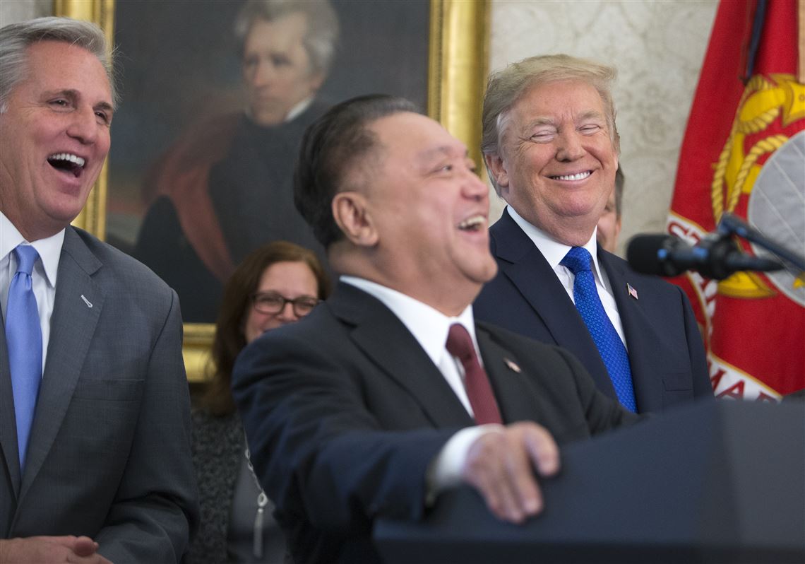 This file photo shows Hock Tan, center, chief executive of Singapore-based Broadcom, with President Donald Trump during a news conference on Capitol Hill in Washington on Nov. 2, 2017.