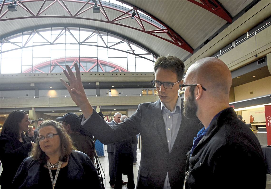 Carnegie Mellon University's Alexandre Jacquillat, assistant professor of operations research and public policy, talks with Alexander Gramsky, an information tech at Pittsburgh International Airport, about how CMU's Metro 21 will make the airport smarter.