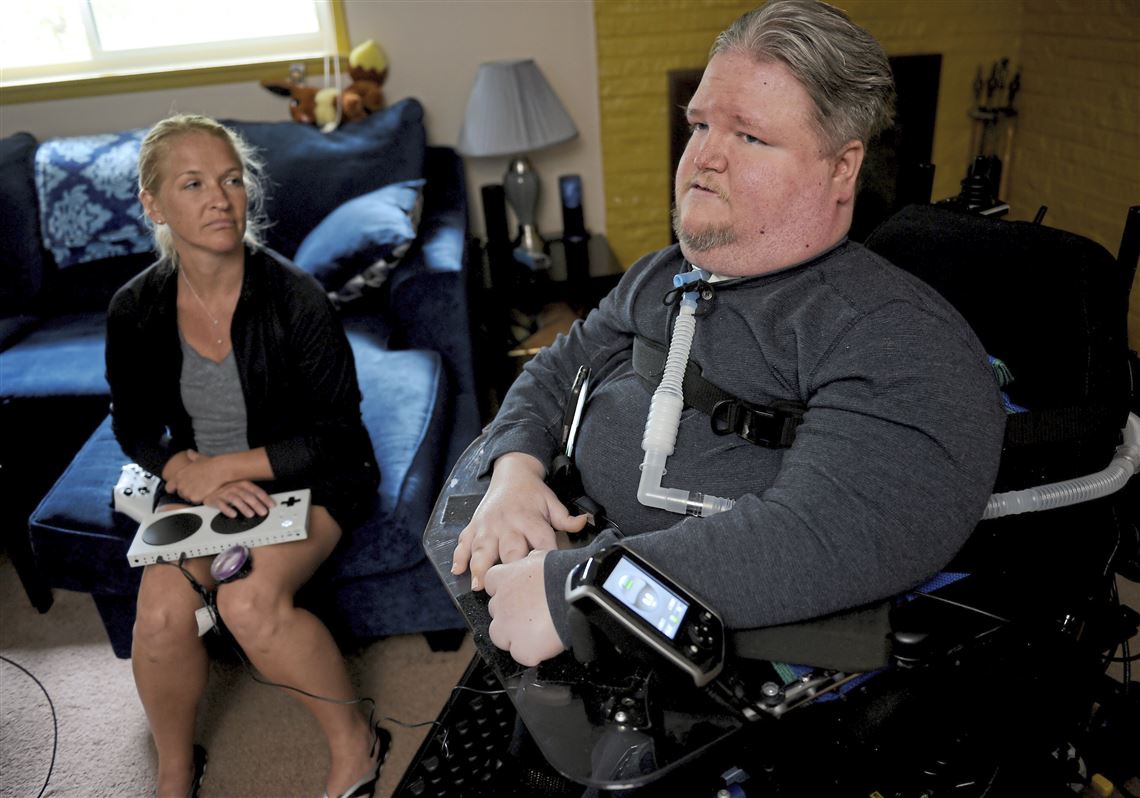 Steven Spohn, COO of The AbleGamers Charity, and his friend Ronelle Clutter demonstrate how the Xbox Adaptive Controller is used, which was developed for the disability community by Microsoft. They are in Mr. Spohn's home in Upper St. Clair. 