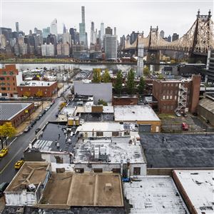 Part of the Long Island City neighborhood of Queens in the foreground, with Manhattan across the East River from it. 