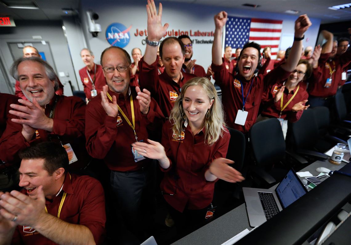 NASA engineers on the flight team celebrate the InSight spacecraft's successfull landing on the planet Mars from the Mission Support area in the Space Flight Operations facility at the NASA Jet Propulsion Laboratory (JPL) in Pasadena, California on November 26, 2018.