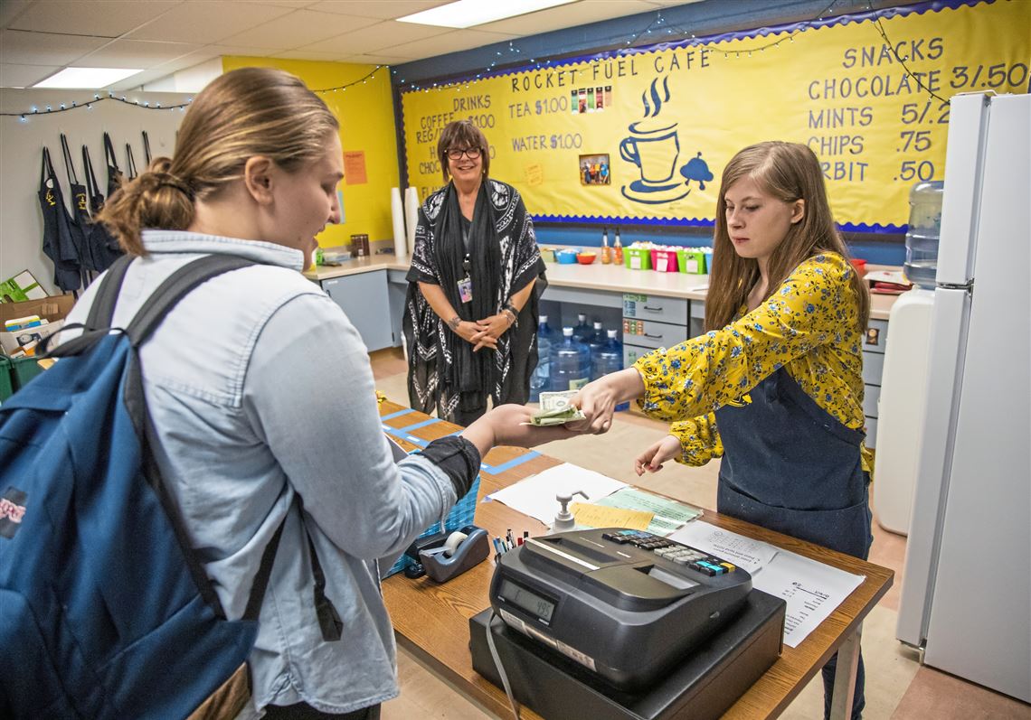 Claire Nailler, 16, right, hands change to fellow student Victoria Whaley in the Rocket Fuel Cafe at Mars Middle School on Tuesday, Feb. 12, 2019, in Mars. The cafe is part of the life skills program at the school. At center is Linda Friedline, a paraprofessional with the district.