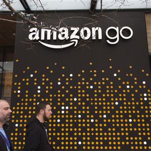 Pedestrians walk past the Amazon Go store in Seattle on Jan. 17, 2018. 