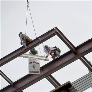 Pittsburgh Iron Workers Local Union #3 maneuver a topping off ceremonial beam into place for Bakery Office Three at Bakery Square. 