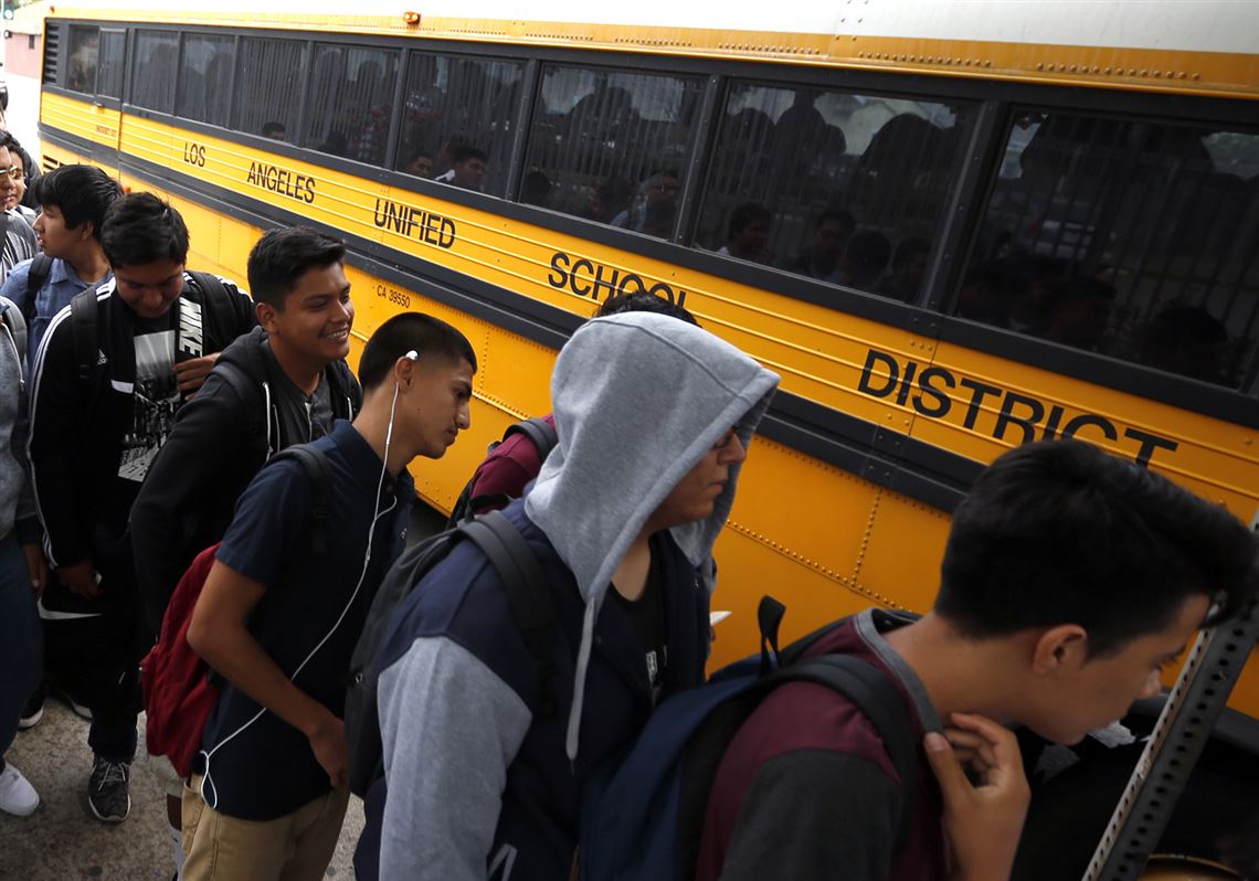 In this file photo, students line up for their buses at a district stop near Jefferson High School in Los Angeles on the first day of classes in 2015. In California, 58% of Latinos attend "intensely segregated schools," a recent report says.