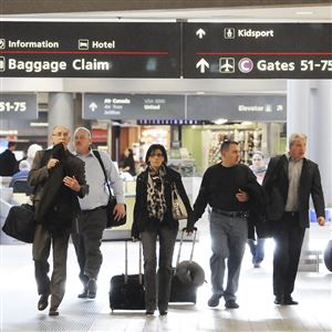 Travelers head to their terminal at the Pittsburgh International Airport. Costs per passenger are increasing for airlines.
