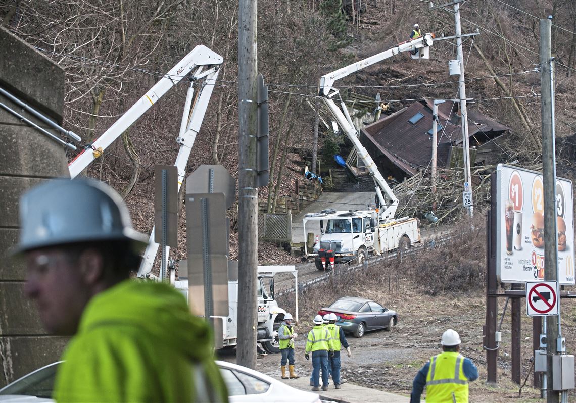 Duquesne Light Company crews work on repairs near a home that was destroyed during a landslide on Greenleaf Street last year in the Duquesne Heights section of Mount Washington.