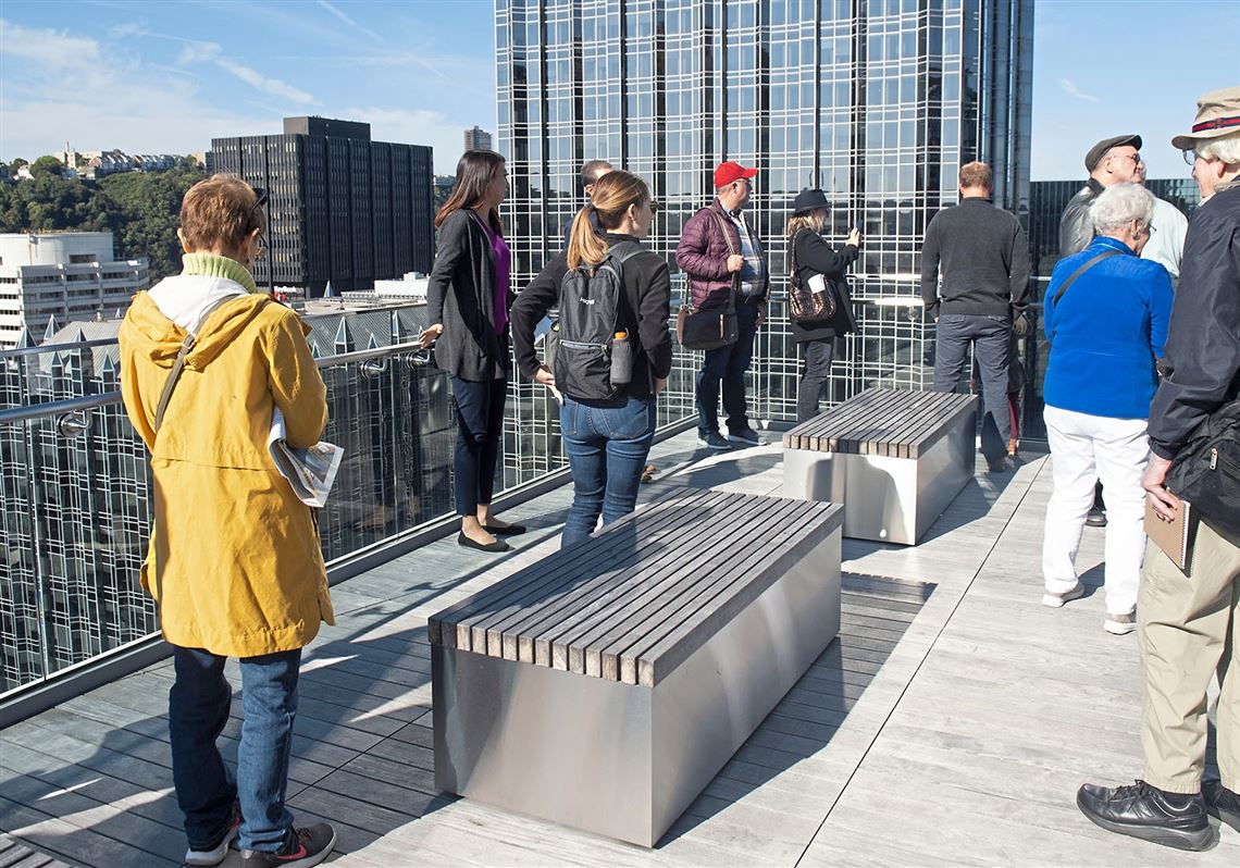 A group looks over the roof-top patio of the Benedum Trees Building during the annual Doors Open Pittsburgh tour downtown Saturday, Oct. 5, 2019 in Pittsburgh. 