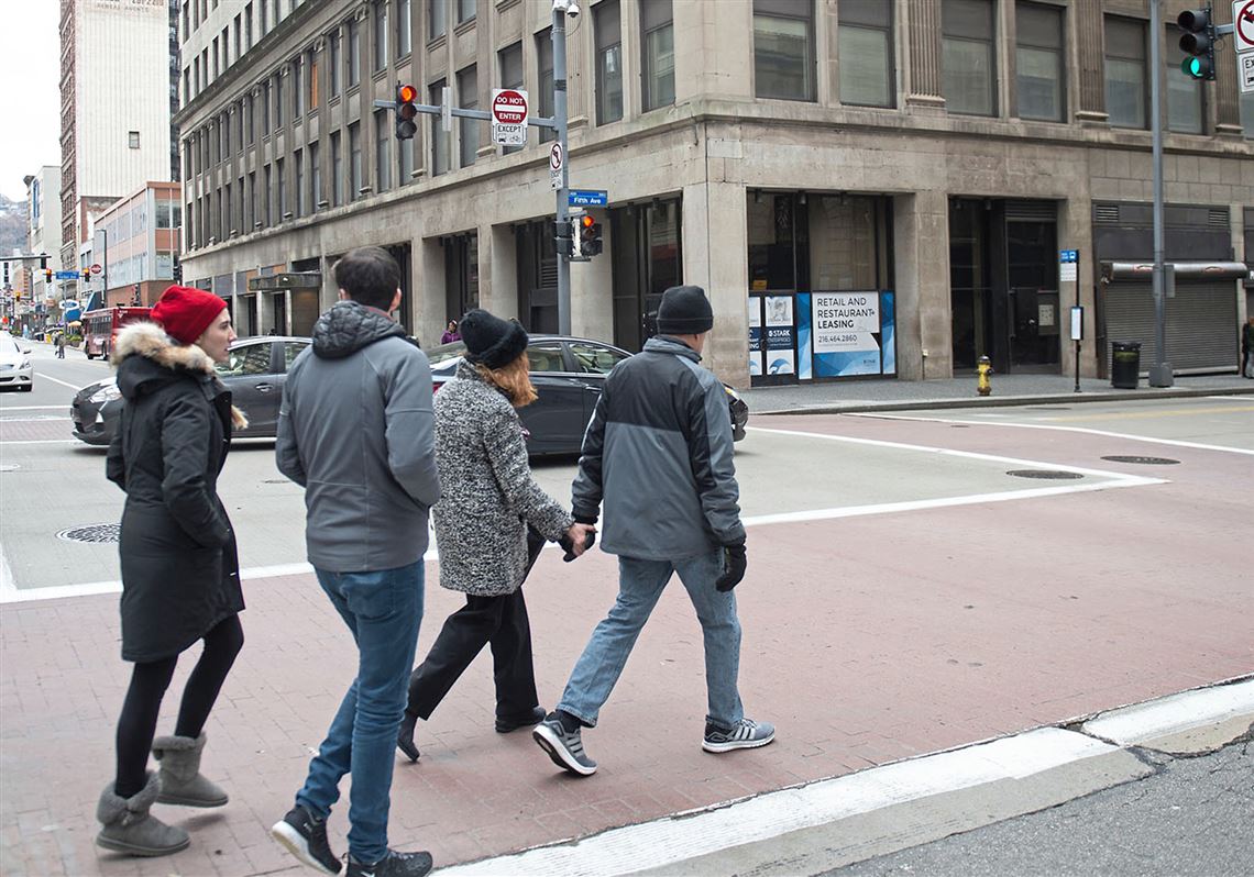Pedestrians cross Smithfield Street at Fifth Avenue, Downtown. Uber self-driving cars are unable to recognize a jaywalker.