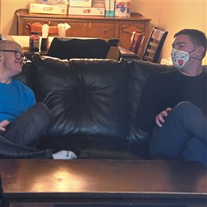 Edward Monk, right, age 30 of Brookline, talks with one of his clients after breakfast in their Mt. Lebanon group home on Friday, April 17, 2020. Mr. Monk works the overnight shift. 