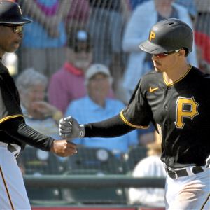 Pirates third base coach Tarrik Brock congratulates left fielder Bryan Reynolds after he hit a home run against the Braves Wednesday, March 4, 2020, at LECOM Park in Bradenton, Fla.