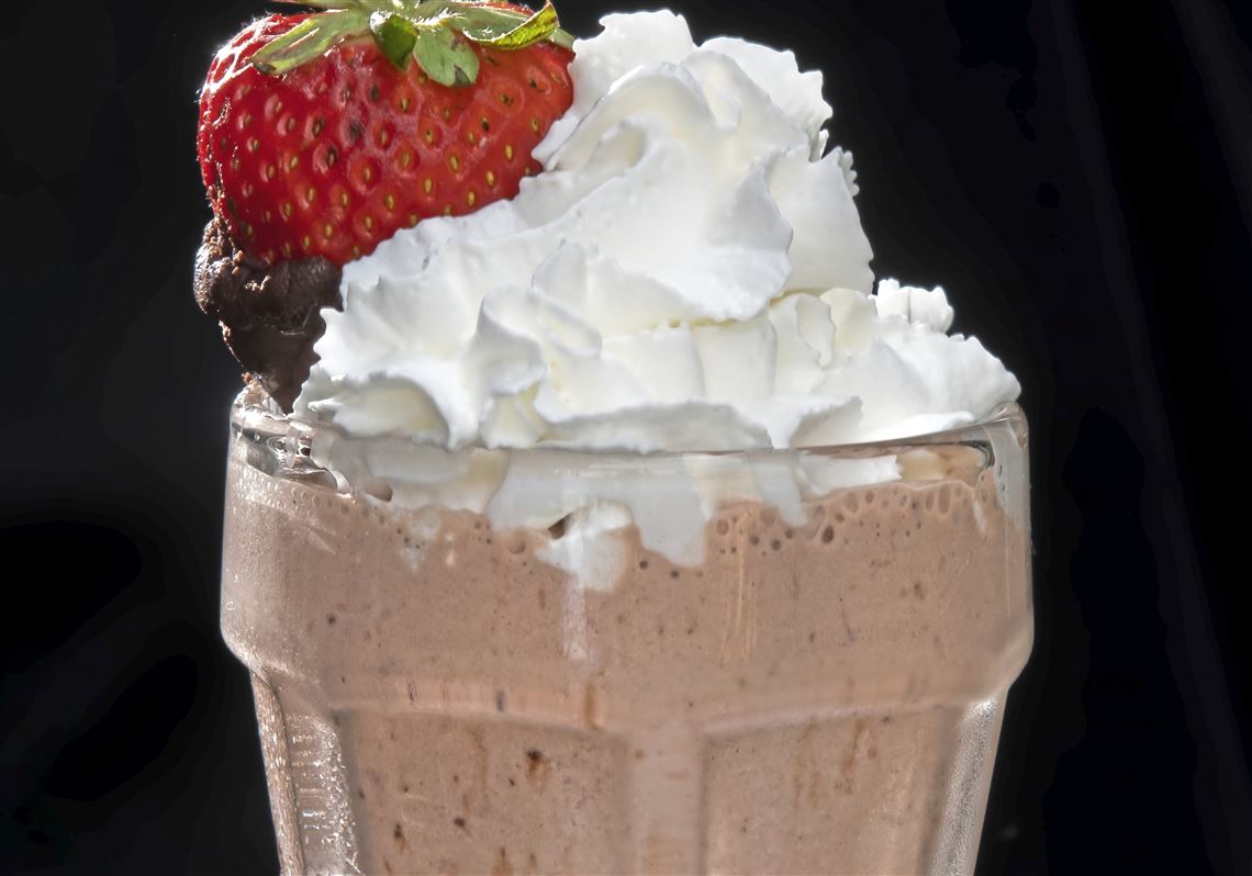 Chocolate-Dipped Bourbon Strawberry Milkshake is made with vanilla bean ice cream, strawberry reduction sauce, hot fudge and a good splash of bourbon. It is garnished with a chocolate-dipped strawberry.  