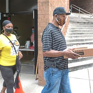 Kevin Brown and Kisha Abram of East Liberty receive an iPad for their son Wednesday, Sept. 2, 2020, at Peabody Early Childhood Center in East Liberty.