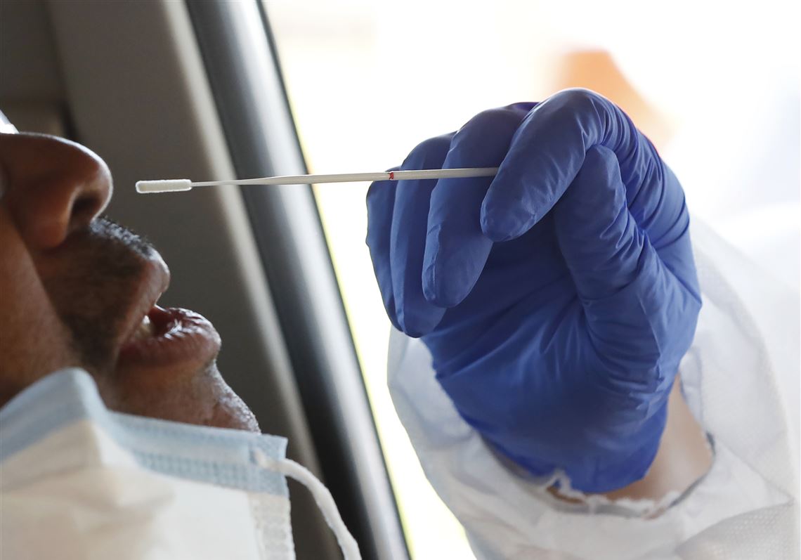 In this April 16, 2020, file photo, a man braces for a nasal swab by one of the Delta Health Center staff at a free drive-thru COVID-19 testing facility at the center's Dr. H. Jack Geiger Medical Center in Mound Bayou, Miss.