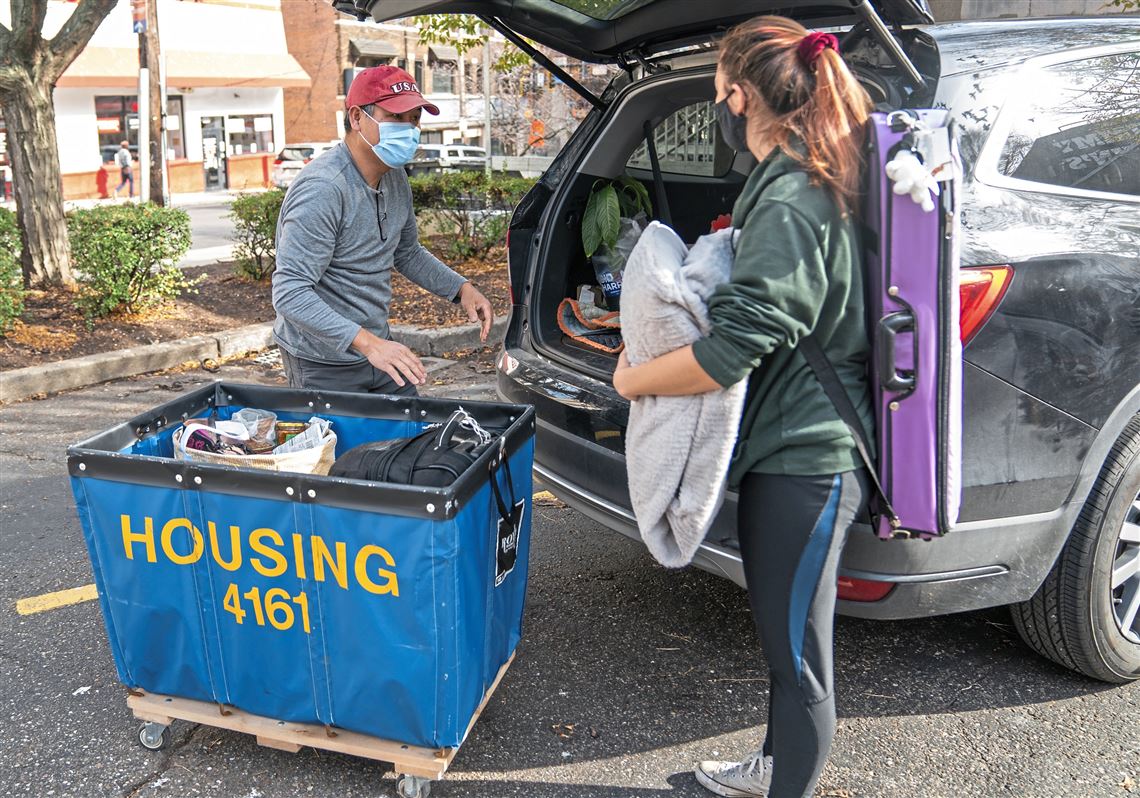 In this file photo, Jan Zhang, of Buffalo, N.Y., helps his daughter Lilliana — a freshman at the University of Pittsburgh — move out of her dorm for Thanksgiving break Nov. 19, 2020 in Oakland.   Pitt on Wednesday, Jan. 13, 2021, advised all students heading for spring semester to the school’s main and regional campuses, and surrounding neighborhoods, that they can arrive starting Jan. 29.