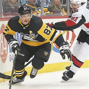 Penguins center Sidney Crosby carries the puck around the back of the goal past Senators defenseman Ron Hainsey, Tuesday, March. 3, 2020, at the PPG Paints Arena Uptown.   