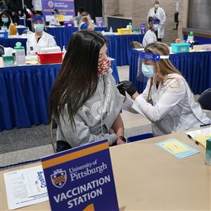 Tiffany Husak, left, a nursing student at the Community College of Allegheny County, receives her first dose of the Moderna COVID-19 vaccine on Jan. 28 during a vaccination clinic hosted by the University of Pittsburgh and the Allegheny County Health Department at the Petersen Events Center in Oakland.