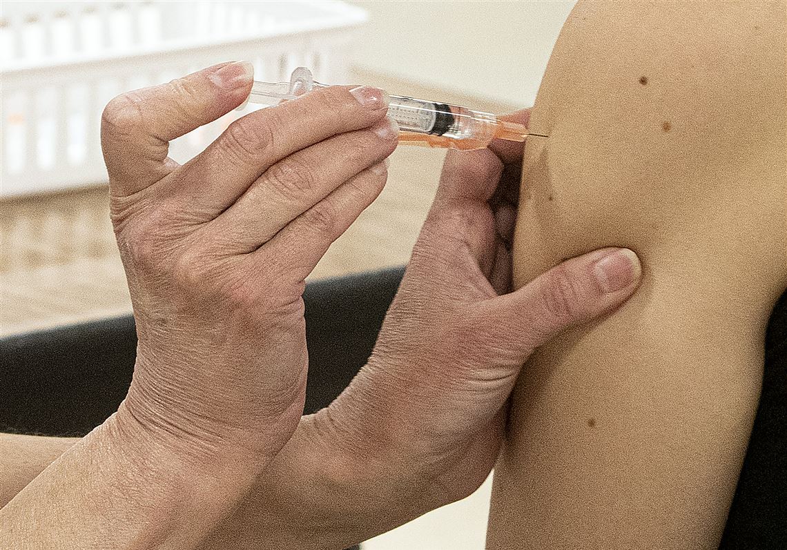 A college student is given a COVID-19 vaccination.