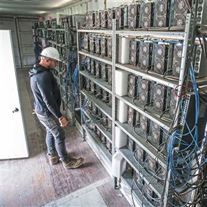 Chris Radwanski, data center supervisor, checks on Bitcoin mining machines in a shipping container behind the Scrubgrass power plant.