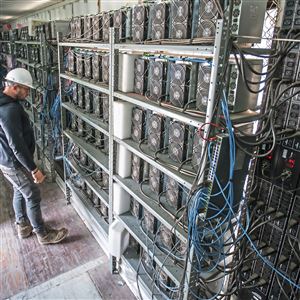 Chris Radwanski, data center supervisor, checks on bitcoin mining machines in a shipping container behind the Scrubgrass Power plant in 2021. Bitcoin lost a third of its value since last fall. Meanwhile, electric power prices rose. In short, it’s more profitable to sell electrons to the grid than to mint crypto coins.