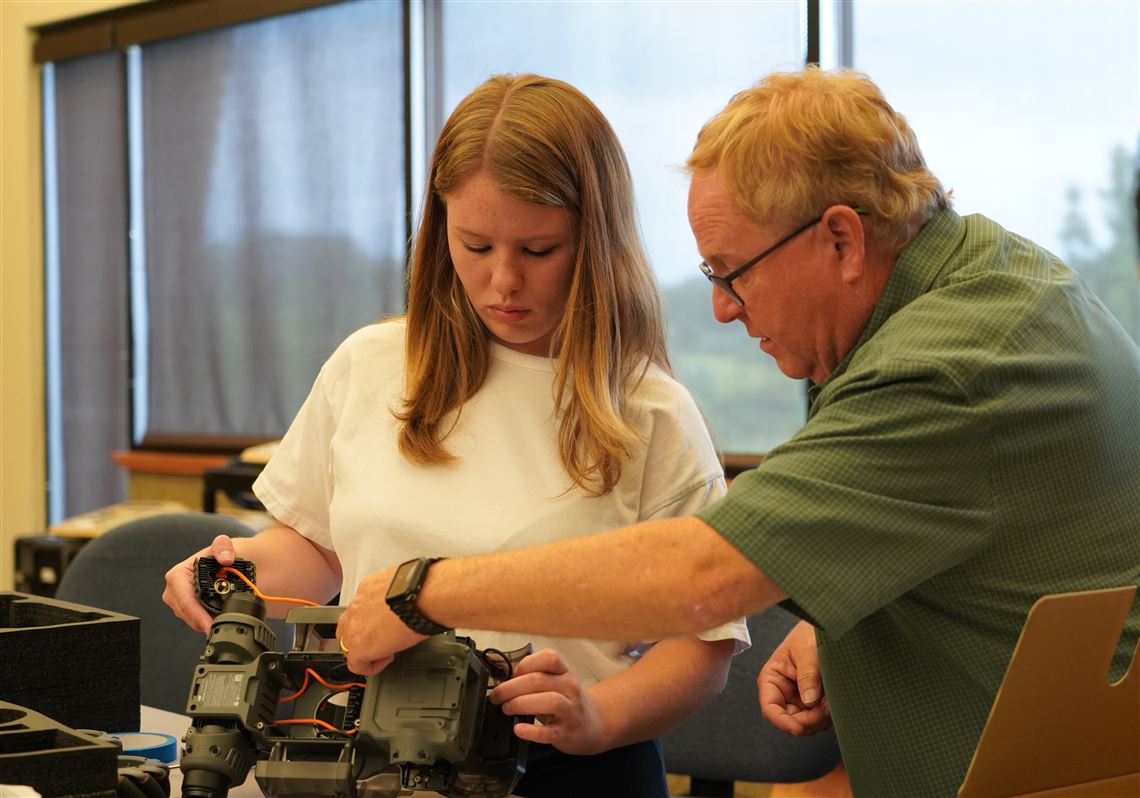 A Pittsburgh Technical College faculty member advises a student while she assembles and programs a robot. PTC has partnered with self-driving vehicle developer Aurora to create an 18-month degree in robotics and autonomous engineering designed to train Service Engineer Technicians 