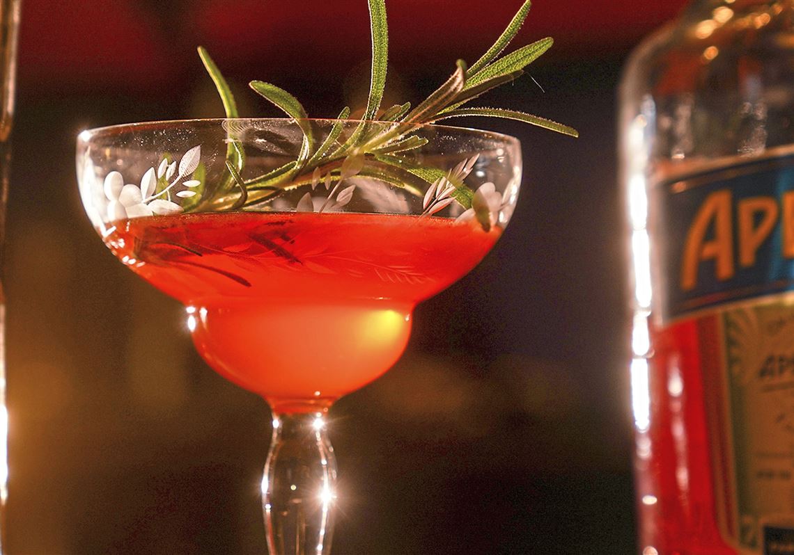 Bill Semins' Aperol cocktail is garnished with a sprig of fresh rosemary from his garden.