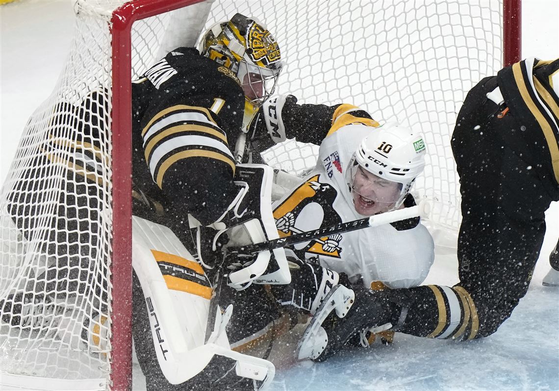 Pittsburgh Penguins left wing Drew O'Connor (10) collides with Boston Bruins goaltender Jeremy Swayman (1) as they slide into the net after O'Connor attempted to score in the first period of an NHL hockey game, Thursday, Jan. 4, 2024, in Boston.