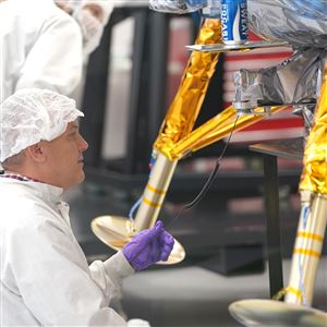An Astrobotic Technology staff member makes an adjustment to check the weight of their Peregrine Lander lunar landing vehicle at the robotics company headquarters on the North Side Thursday, August 31, 2023.