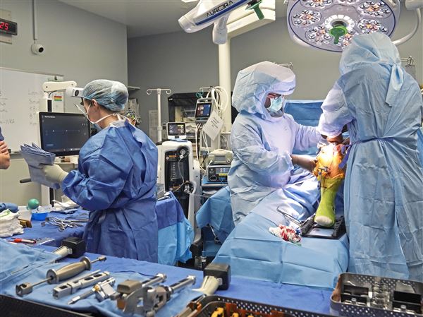 UPMC surgeon Dr. Ken Urish, right, and his team perform a robotics assisted knee replacement at UPMC Magee-Womens Hospital in Oakland Friday, Oct. 25, 2024. 