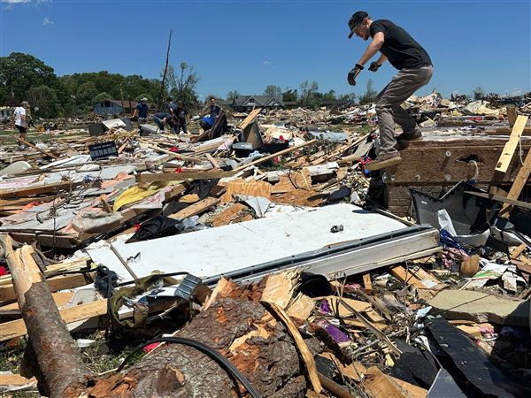 A person looks through a home that was damaged after severe weather passed the area London, Ky., on Saturday.