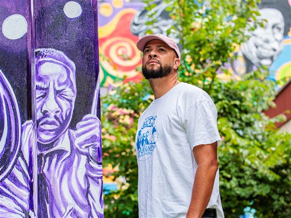 Kyle Holbrook stands next to a mural he created at the Afro-American Music Institute, Homewood, in 2023. Two of his murals, one in Miami and another in Oakland, Calif., were defaced with racial epithets and a swastika in the past two weeks.