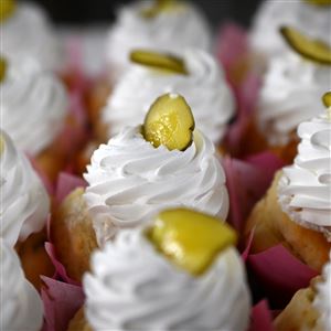 Patti Schvabenitz puts a single pickle slice on top of  special cupcakes Patti’s Pastries serves at Picklesburgh.