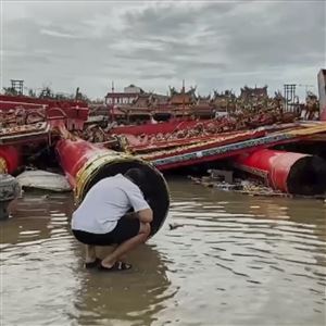 In this image made from a video provided by TVBS, a resident checks the collapsed temple structures submerged in floodwaters Monday, July 7, 2025, after the Typhoon Danas landed in Tainan, Taiwan.