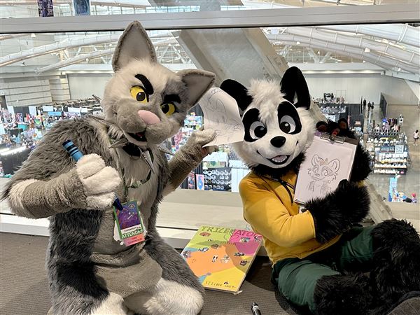 Cooper Tom from New Jersey and Paco the Panda from Mexico engage Anthrocon attendees through “Doodling for Donations” to benefit Nose 2 Tail. 