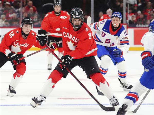 Canada's Gavin McKenna (9) skates with the puck as United States' Drew Fortescue (5) defends during the second period of an IIHF World Junior Hockey Championship tournament game in Ottawa, Ontario, Dec. 31, 2024.