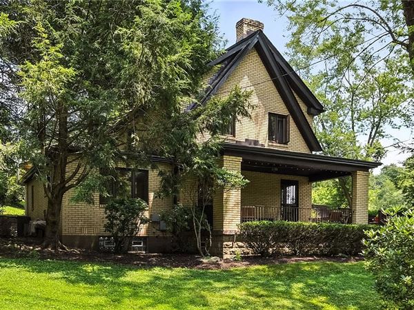 There is a large covered porch at the front of the house at 115 Forest Hills Road in Forest Hills.