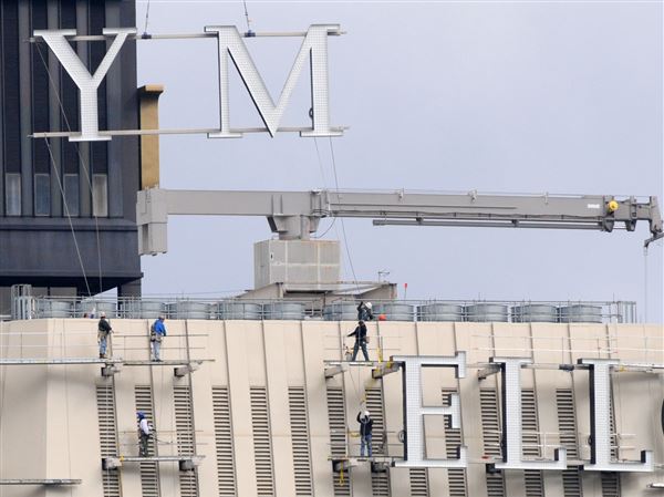 Crews work on the sign atop the BNY Mellon Center on Oct. 31, 2010.