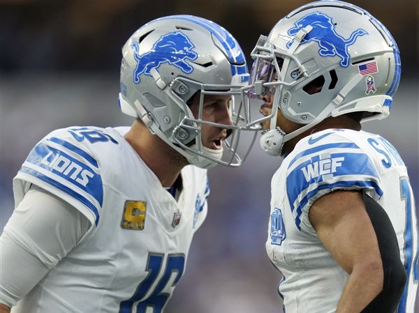 Detroit Lions quarterback Jared Goff, left, and wide receiver Amon-Ra St. Brown celebrate a touchdown catch against the Los Angeles Chargers in a game in November 2023.