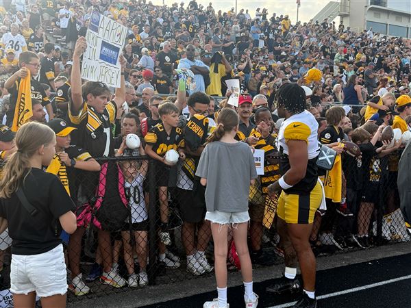Steelers running back Jaylen Warren signs autographs and take pictures with fans before the "Friday Night Lights" practice Aug. 1, 2025, at Latrobe Memorial Stadium. 